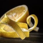 cáscara de limón con limón de fondo, increíbles beneficios de la cáscara: vitamina c, rica en fibra, antioxidantes y aceites esenciales.