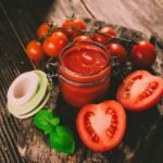 salsa o aderezo de tomate y tomates frescos en un fondo rustico
